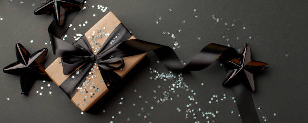 istock Christmas silver decor and handmade gift box on black background top view. Merry Christmas greeting card, frame. Winter xmas holiday theme. Happy New Year. Sale 1266682744