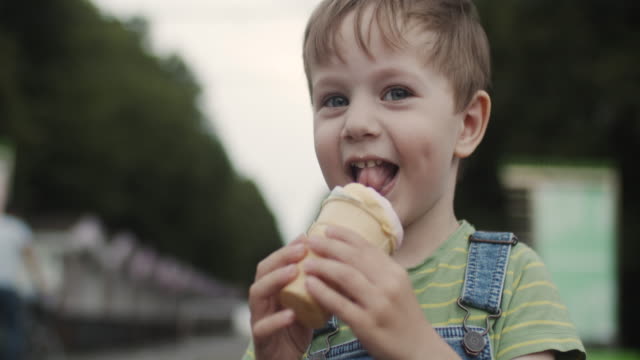 Little boy eating ice-cream outdoors in summer