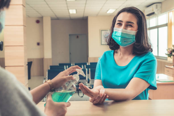 istock Receptionist and guest wearing face mask at front desk . 1266685287