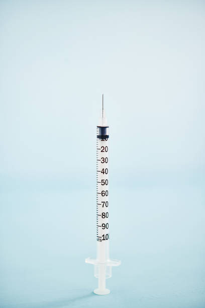 istock Close up shot of a hypodermic needle on a blue background 1266687676