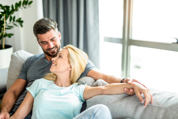 istock Happy young couple relaxing together on sofa. 1266688581