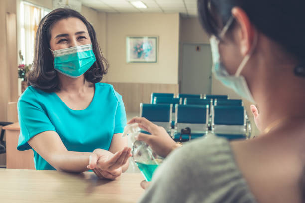 istock Receptionist and guest wearing face mask at front desk . 1266688647
