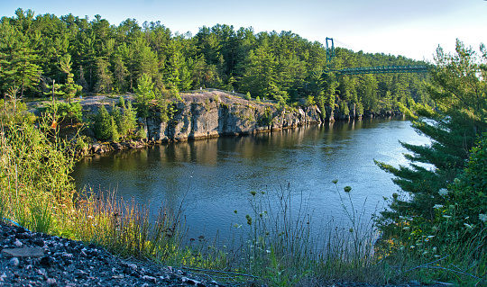 Scenic view of French River gorge and snowmobile pedestrian bridge in French River Provincial Park in summer. It's the longest snowmobile bridge in the world.
