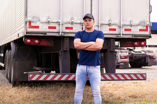 Photo of  brazilian trucker beside a truck.