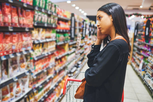 Think it's time for a change Shot of a young woman shopping in a grocery store woman pushing tire stock pictures, royalty-free photos & images