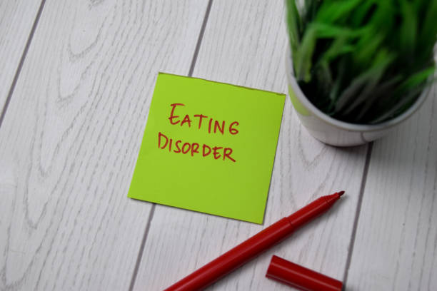 istock Eating Disorder write on sticky note isolated on wooden table. 1266709615