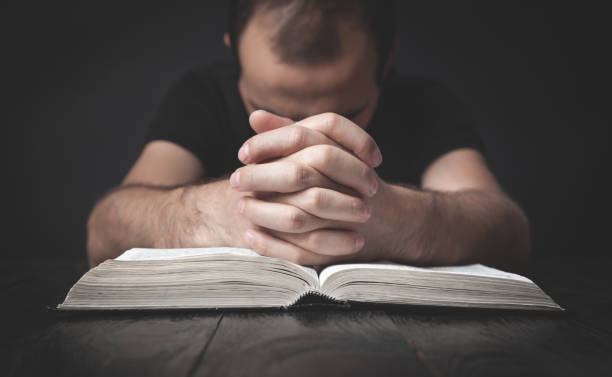istock Caucasian man praying in the dark room. 1266716746