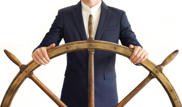 Businessman holding ship rudder.