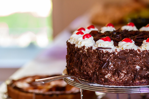 Chocolate cake with whipping cream,  cherry and chocolate for garnishing