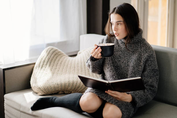 istock Woman enjoy hot chocolate and reading a book 1266720591