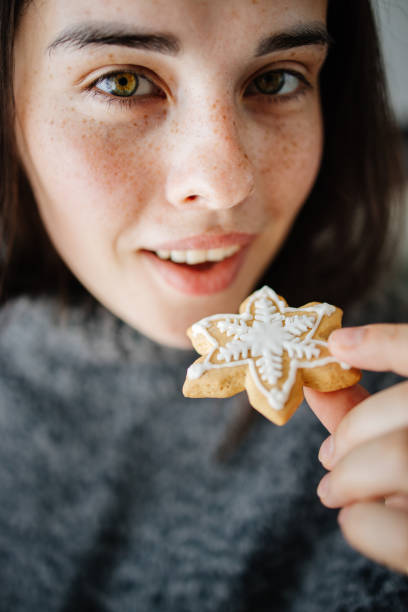 istock Woman eating Christmas gingerbread, close up 1266720611