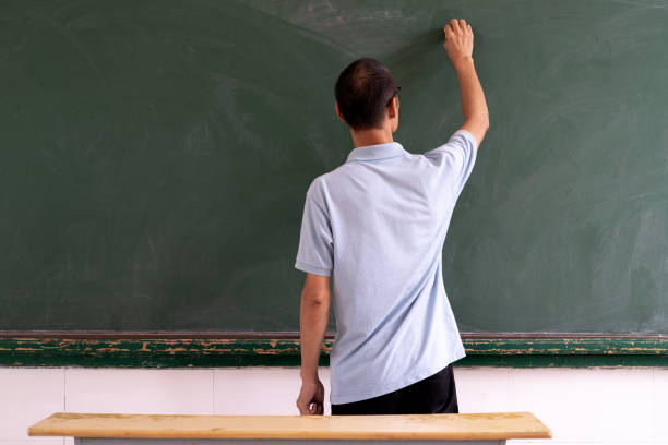 istock Middle-aged man writing in front of blackboard 1266721561