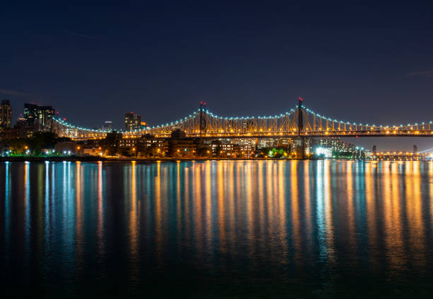 queensboro bridge with east side of midtown manhattan, illuminated at night, new york, usa - queensborough bridge imagens e fotografias de stock