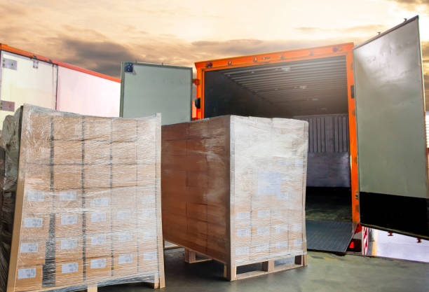 istock Cargo freight, Shipment, Delivery service. Warehouse docks. Stacked package boxes on pallet waiting to load into cargo container truck. Logistics and transportation. 1266725199