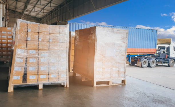 istock Cargo freight, Shipment, Delivery service. Logistics and transportation. Warehouse docks. Stacked package boxes on pallet waiting to load into cargo container truck. 1266725211