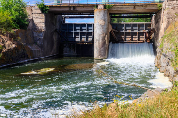 Flowing water with water spray from the open sluice gates of a small dam Flowing water with water spray from the open sluice gates of a small dam sluice photos stock pictures, royalty-free photos & images