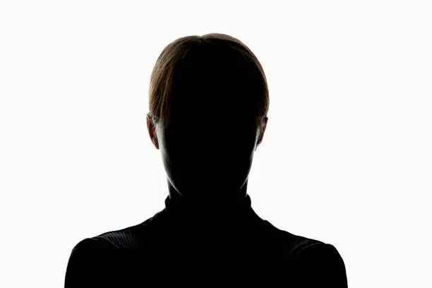 Photo of Dark silhouette of girl isolated on white background, the concept of anonymity