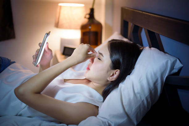 istock Woman is feeling eye pain when using smart phone at night 1266727374