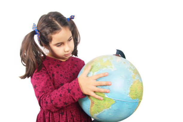istock Cute girl looking at globe 1266728627