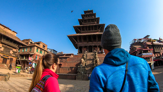 A couple walking on Taumadhi square towards Nyatapola Temple in Bhaktapur, Nepal. The Hindu temple has five stories. Discovering new cultures. A place of religious and historical worship. Spirituality