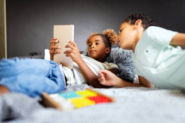 istock Happy children havig fun and using technology devices 1266728753