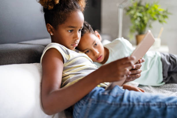 istock Happy children havig fun and using technology devices 1266728760
