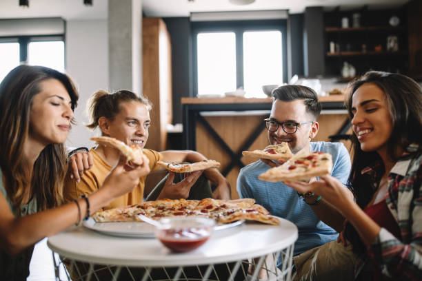 istock Cheerful group of friends having fun at home,eating pizza. 1266729263