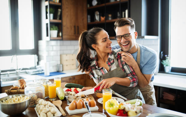 istock Beautiful couple is smiling while cooking together in the kitchen 1266729336