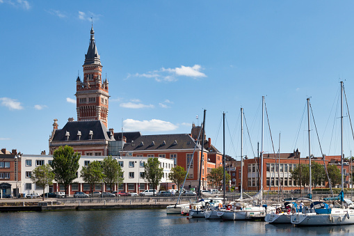 Dunkerque, France - June 22 2020: The Port du Bassin du Commerce with the belfry of the Dunkirk city hall behind it.