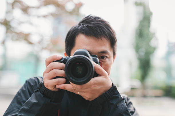 istock Man photographing with DSLR 1266732084