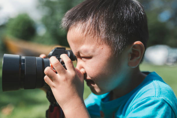 istock Boy photographing with DSLR 1266732126