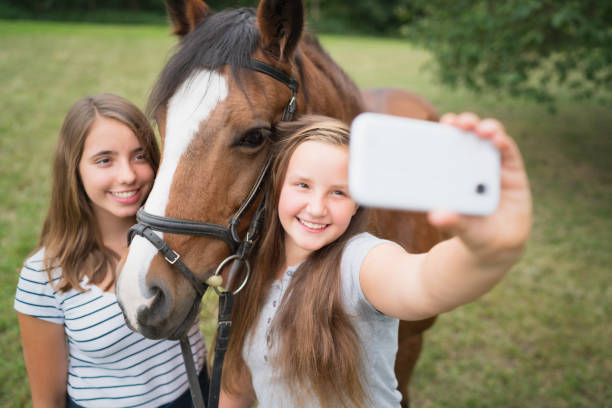 jeunes filles prenant des selfies avec leur cheval - horse animal head laughing animal photos et images de collection