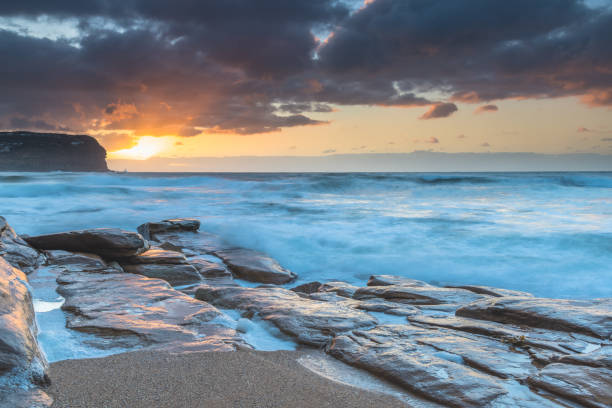 istock Sunrise at the beach with waves and clouds 1266736062