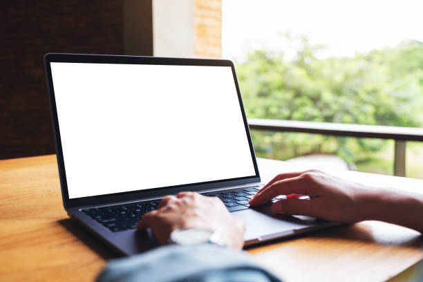 istock a woman using and typing on laptop computer keyboard with blank white desktop screen on wooden table 1266736396