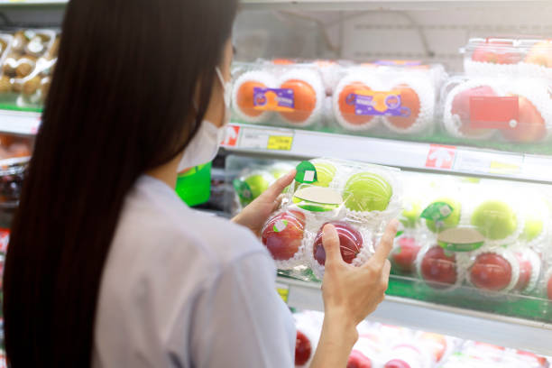 Women long hair wear protective face mask hands holding green and red apples ipackage. Asian female shopping at supermarket, Grocery to buy some food. New normal after covid-19 concept. las mujeres de pelo largo llevan las manos protectoras máscara de la cara sosteniendo manzanas verdes y rojas ipackage. asiáticas compras femeninas en el supermercado, grocery para comprar algo de comida. nuevo concepto normal después de covid-19.