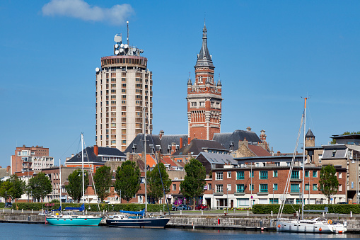 Dunkerque, France - June 22 2020: The Port du Bassin du Commerce with the Tower of Reuze and the belfry of the Dunkirk city hall behind it.