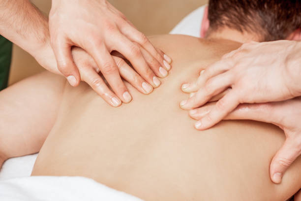 back massage in four hands. - massage therapist massaging sport beautician imagens e fotografias de stock