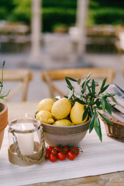 istock Deep plate with lemons on the table with a sprig of cherry tomatoes on a blurred background. 1266739959