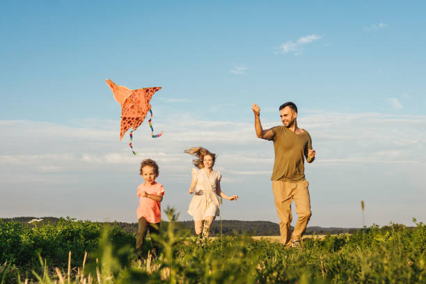 istock Happy family flying a kite 1266743650