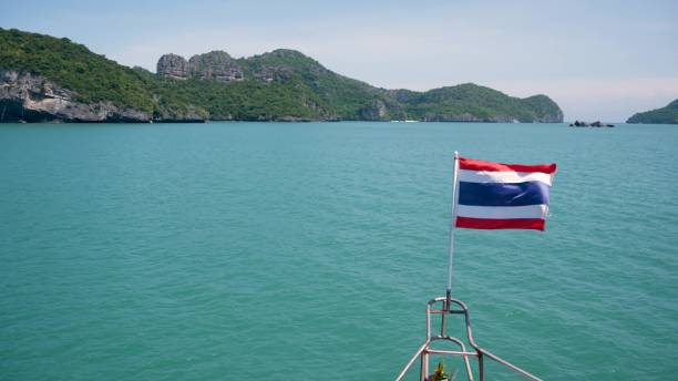 grupo de islas en el océano en el parque marino nacional ang thong. archipiélago en el golfo de tailandia. idílico fondo natural de mar turquesa con espacio de copia. ondeando la bandera como símbolo nacional en el barco. - ang thong islands fotografías e imágenes de stock