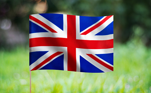British flag waving on a green background. Horizontal composition with copy space.