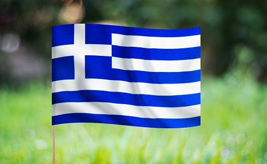 Greek flag waving on a green background. Horizontal composition with copy space.