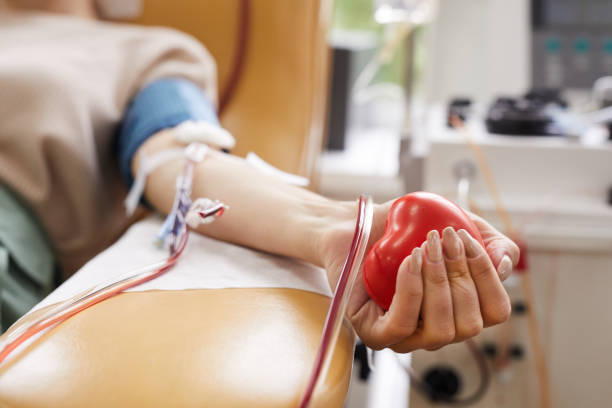 Patient lying at hospital Close-up of patient with tubes in her arm squeezing the ball in her hand while donating the blood blood bank stock pictures, royalty-free photos & images