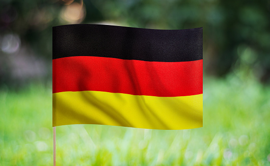German flag waving on a green background. Horizontal composition with copy space.