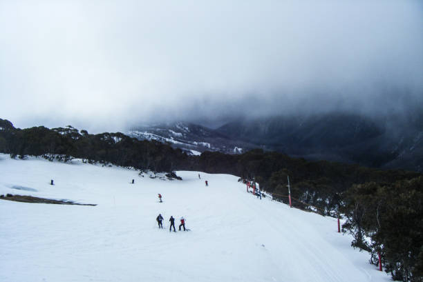 istock Ski Slope and snow fields covered with a cloud and people skiing 1266748815