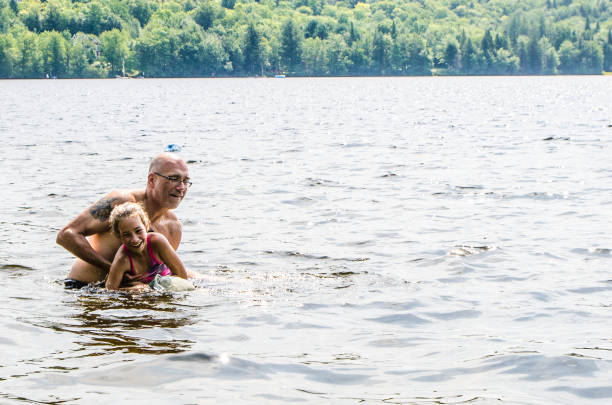 istock Father holding daughter in lake 1266750502