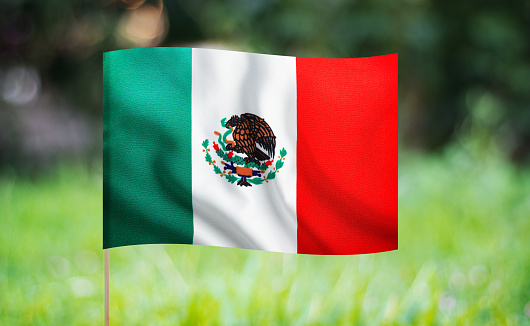 Two Mexico's flag on a blue sky, sunny day