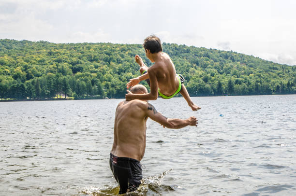 istock Father throwing son in lake 1266751244
