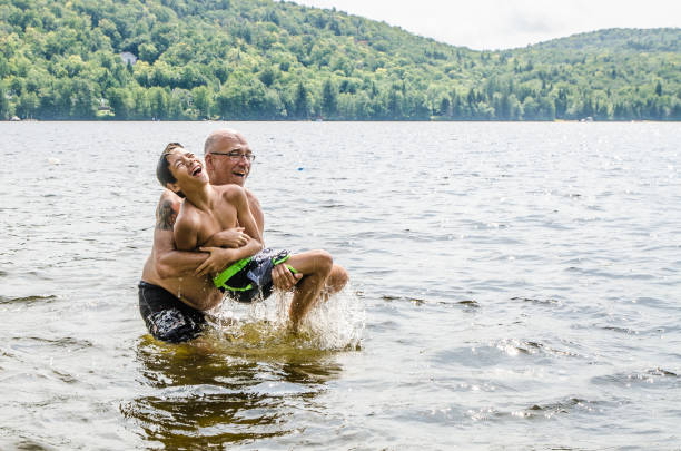 istock Father throwing son in lake 1266751270