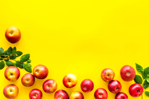 istock Frame of red apples with green leaves top view 1266751714
